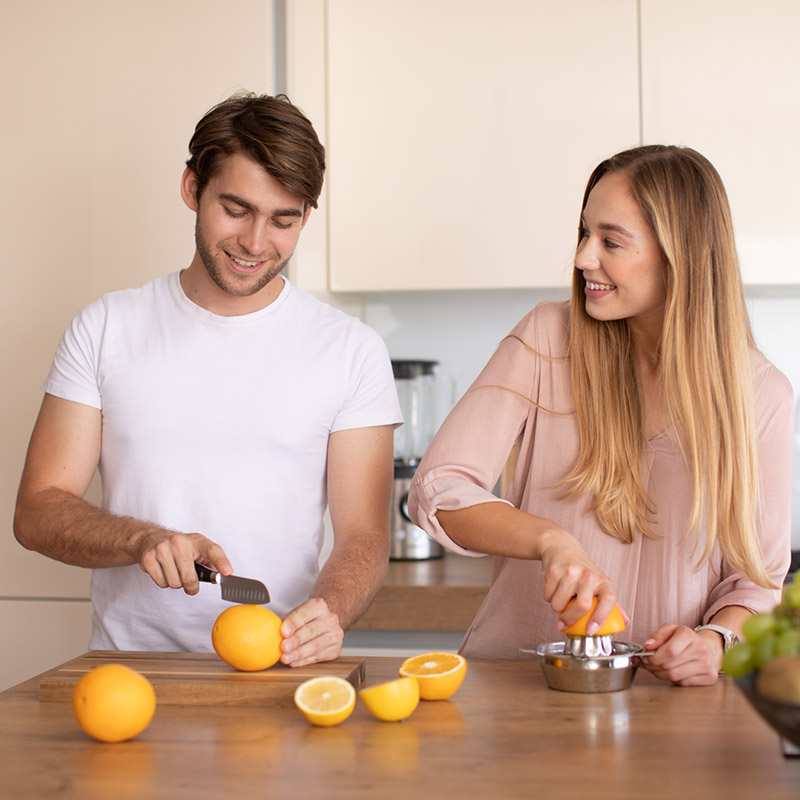 Young couple squeezing lemons in the kitchen