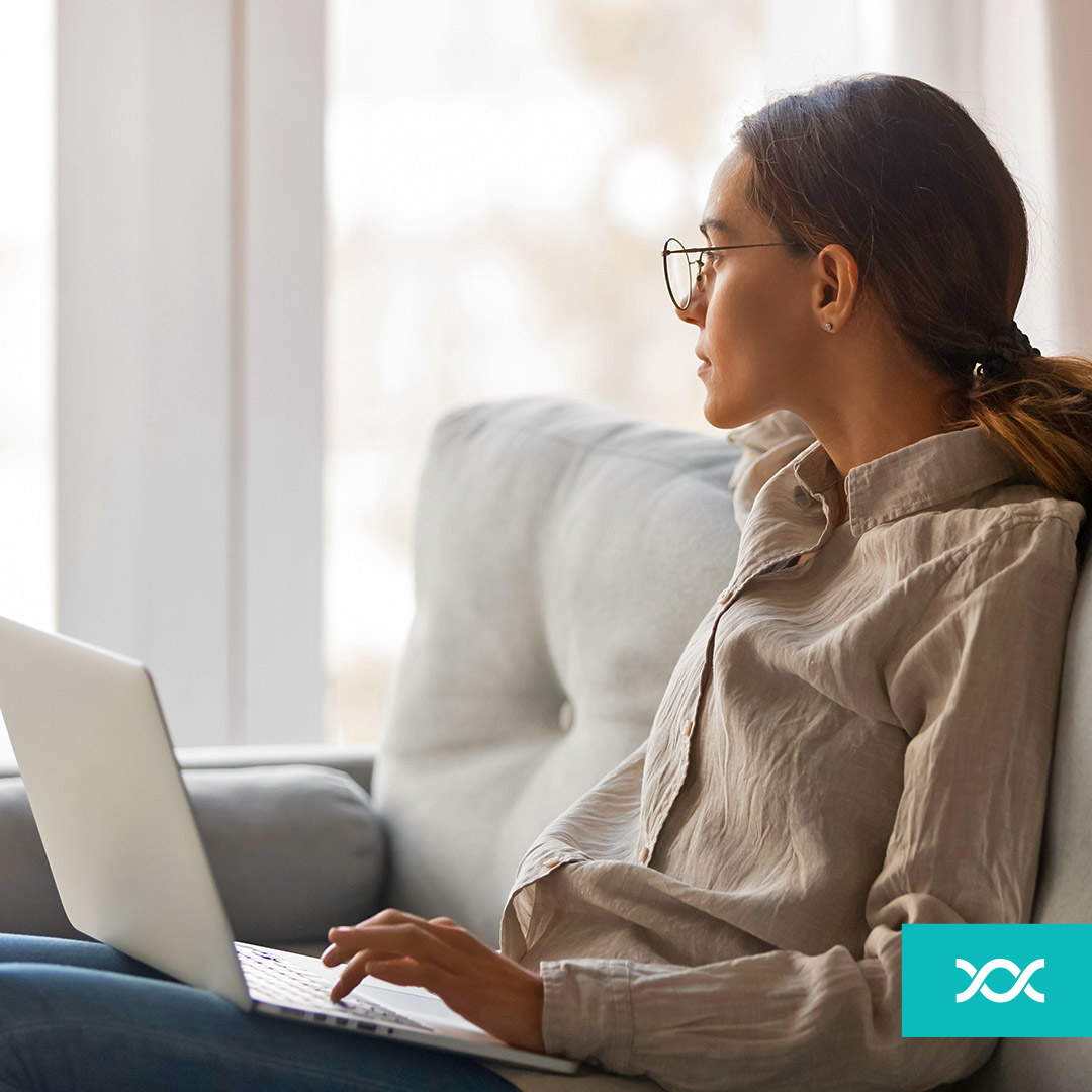 Woman sitting on a sofa with a laptop in her lap